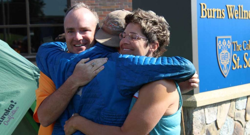 Two parents embrace their child at the family seminar of an outward bound intercept course. 